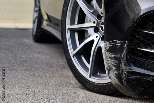Foto Black bumper car scratched with deep damage to the paint.