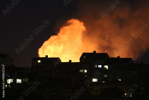 Huge fire and subsequent explosion in a residential neighborhood at night. House fire. Huge fire that destroyed a house