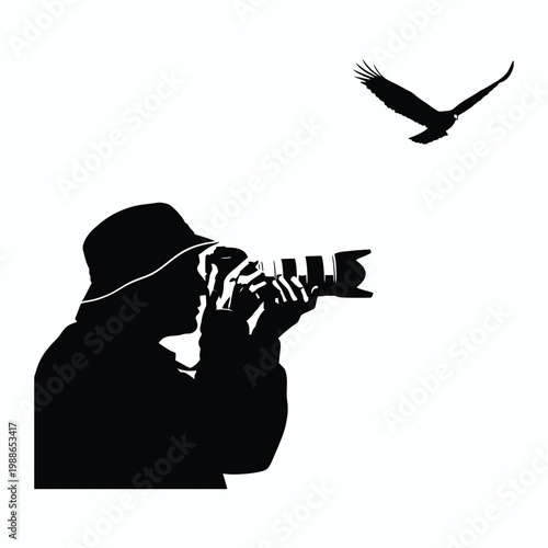 Silhouette of a professional photographer with telephoto lens camera shooting a flying bird in nature