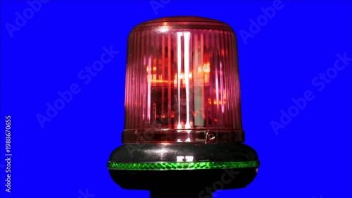 Rotating emergency warning light flashing red against a blue background safety concept.