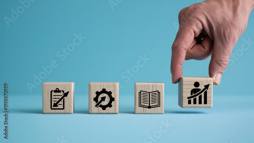 A hand placing a wooden block with a graph icon on a blue background with other blocks