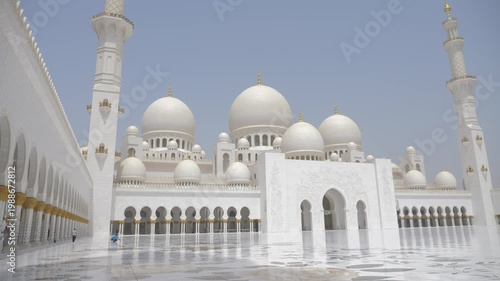 White mosque in Abu Dhabi. Vast marble courtyard surrounded by domes and colonnades