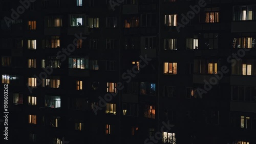 Residential building in Eastern Europe shown in a time lapse from daylight to night and back, with flickering windows emphasizing human activity and time flow