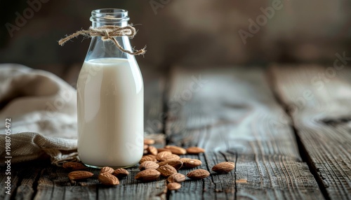 Almond Milk in Glass Bottle with Almonds on Wooden Table.
