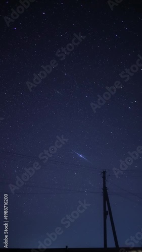 Meteor shower illuminating the night sky with a utility pole silhouette