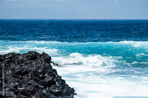 Turquoise ocean waves crashing on volcanic rocks coastline in Tenerife Canary Islands Spain, powerful Atlantic sea, blue water motion, dramatic seascape, summer travel destination, natural energy