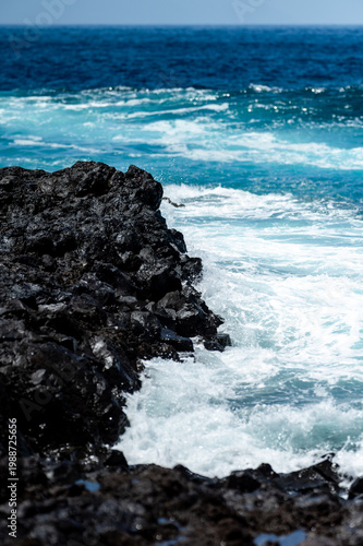 Turquoise ocean waves crashing on volcanic rocks coastline in Tenerife Canary Islands Spain, powerful Atlantic sea, blue water motion, dramatic seascape, summer travel destination, natural energy