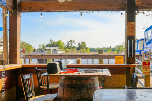 Cuadro en lienzo A rustic themed waterfront restaurant along the coast of the early American town of Georgetown, South Carolina, with a checker game on a barrel table and alligator warning sign in view