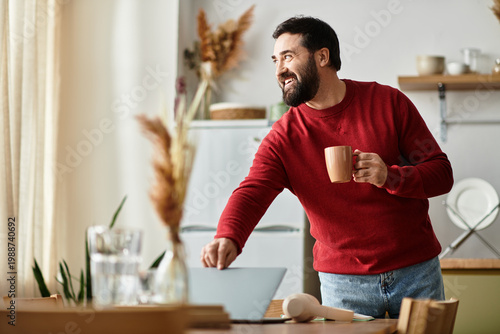 Fotografia Handsome man enjoying a cozy moment at home while preparing a warm drink