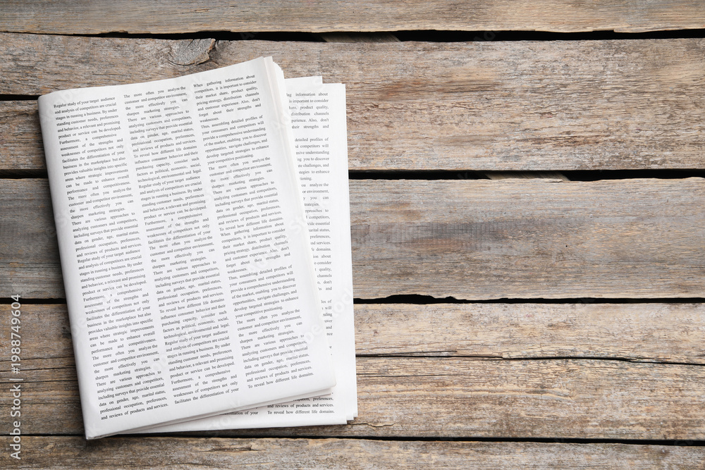 Obraz premium Folded newspaper on wooden background, top view