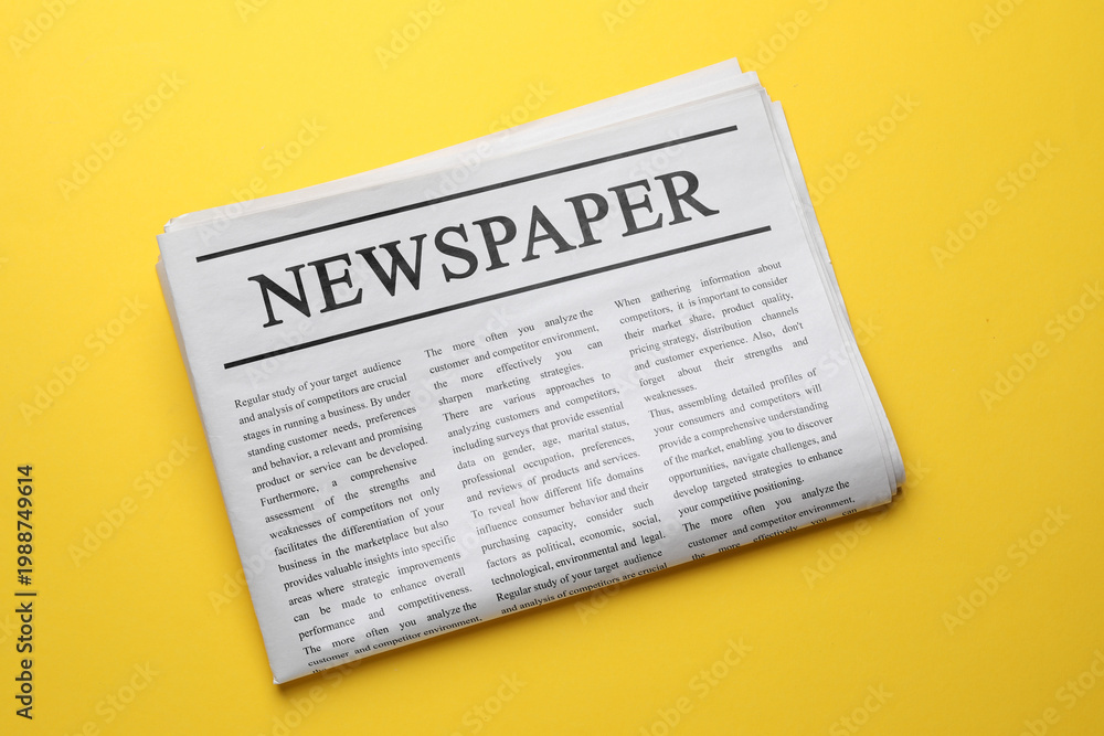 Naklejka premium Folded newspaper on orange background, top view