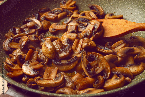 fried mushrooms in a frying pan, with a wooden fork, homemade, no people,