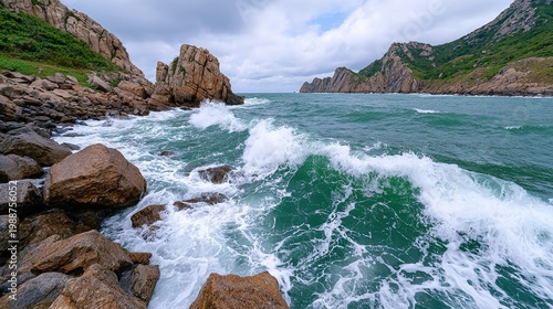 Stormy sea with large waves crashing against a rocky coastline under an overcast sky.
