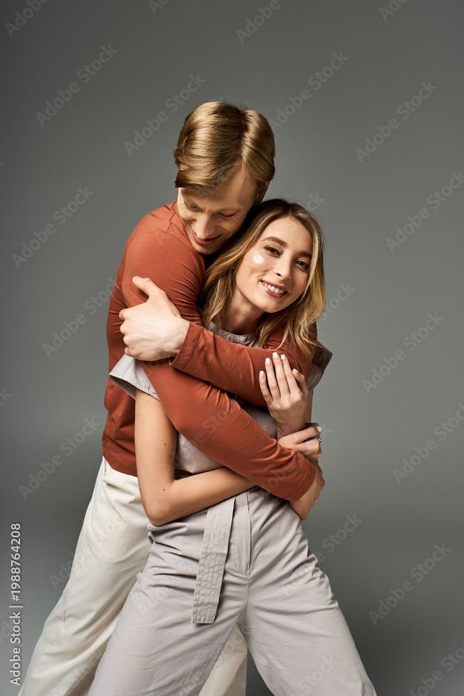 Fototapeta premium Stylish couple embraces in a spring-themed studio setting with vibrant outfits