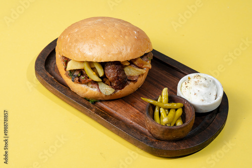 Tombik doner kebab on wooden tray isolated on yellow background