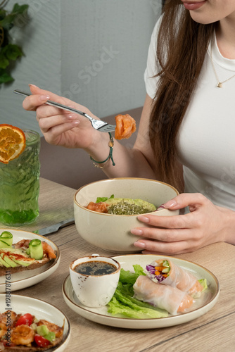 Woman eating salad. Lunch food assortment