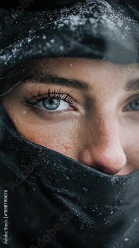 Winter portrait of a person in snow with focus on eyes and expression in cold weather during a snowy day