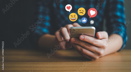 Person using smartphone scrolling social media with emojis and likes popping up.