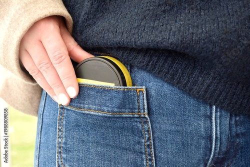 Fotografie The girl takes a box of snus out of her jeans pocket.