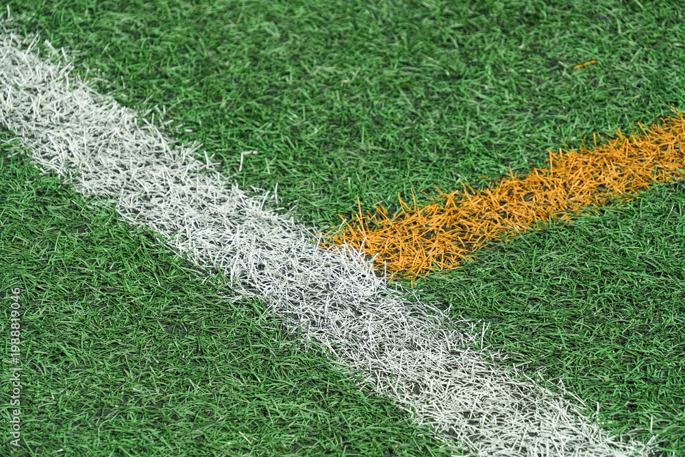 Fototapeta premium Green synthetic grass, artificial turf sports field with yellow and white lines.
