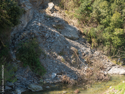 Landslide on a rocky hillside next to a small stream