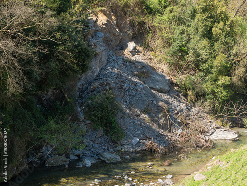 Landslide on a rocky hillside next to a small stream
