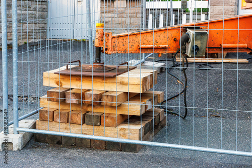 Photos Stacked wooden cribbing supporting crane outrigger behind safety fence