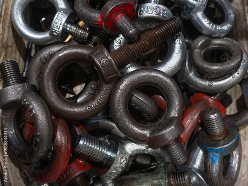 Close up pile of assorted heavy duty metal eye bolts