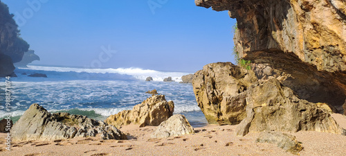 Foto Rocky coast with turquoise water and blue sky, Rocks on the beach