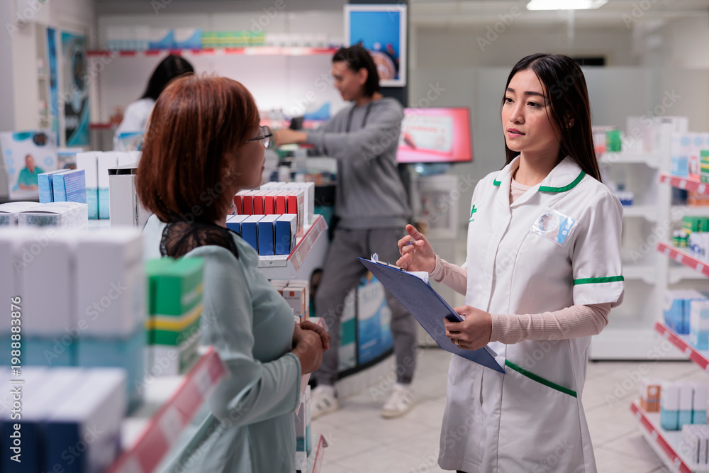 Fototapeta premium Asian customer asking pharmacist about medication pills, giving advice and support to buy medicaments and pharmaceutical supplements. Women talking about health care products.