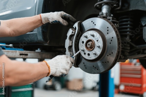 Mechanic working on car brake disc in auto repair shop