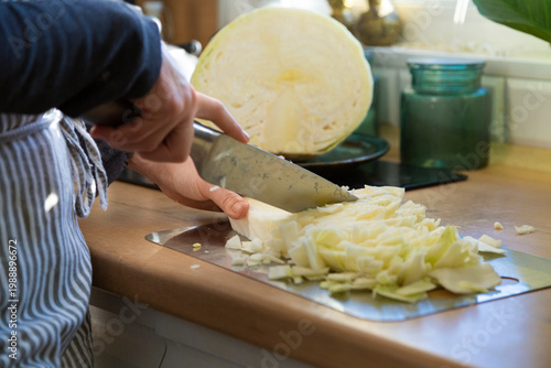 Woman slicing white cabbage for healthy meal preparation