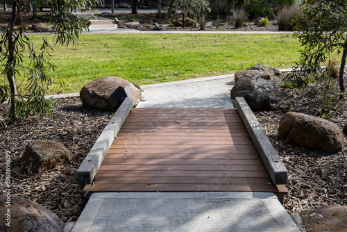 Принти на полотні A pedestrian footbridge spans a stormwater drainage swale in a community park