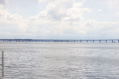 Panoramic view of the President Costa e Silva Bridge, known as Rio-Niteroi Bridge, crossing the Guanabara Bay in Rio de Janeiro, Brazil, with a vast cloudy sky and ripples on the water