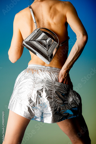Shirtless Model With Metallic Shorts And Bag