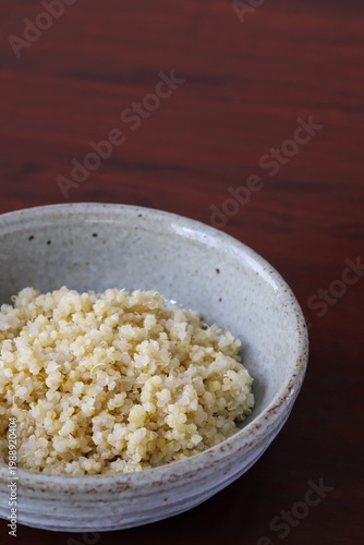 A close up shot of some freshly cooked quinoa in Japanese style food bowl on wooden table