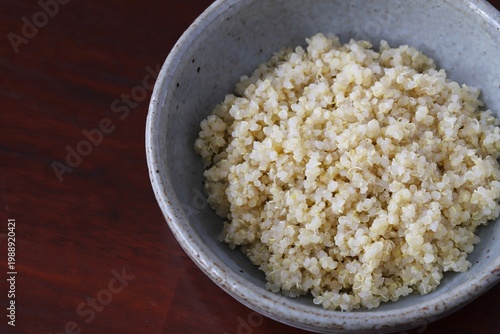 A close up shot of some freshly cooked quinoa in Japanese style food bowl on wooden table