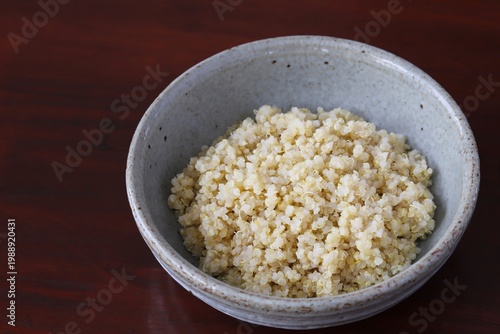A close up shot of some freshly cooked quinoa in Japanese style food bowl on wooden table