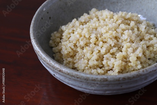 A close up shot of some freshly cooked quinoa in Japanese style food bowl on wooden table