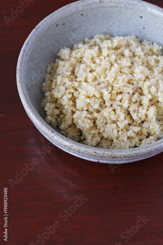 A close up shot of some freshly cooked quinoa in Japanese style food bowl on wooden table