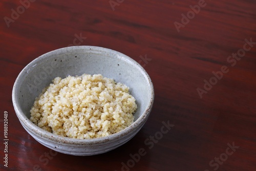 A close up shot of some freshly cooked quinoa in Japanese style food bowl on wooden table