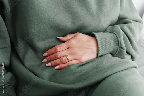 Foto Woman holding stomach in soft loungewear