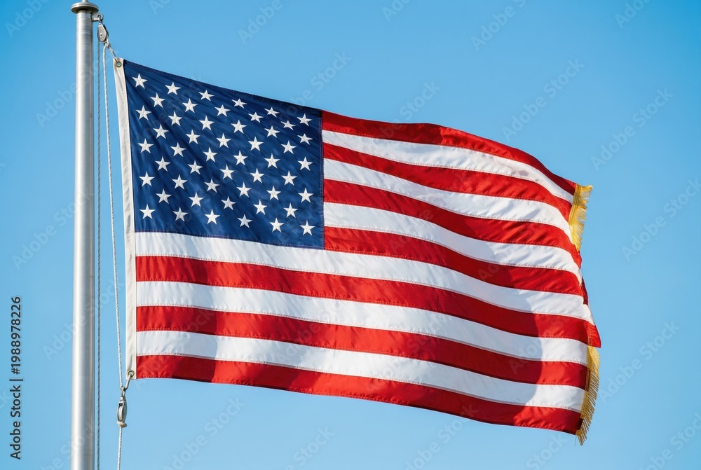 Fototapeta premium American flag waving on a pole under a clear blue sky