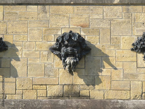 Konstfotografi Bronze Grotesque Mascaron Face Fountain Spout on a Classic French Château Stone
