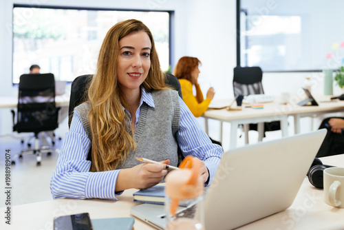 Businesswoman smiling while working in modern office environment