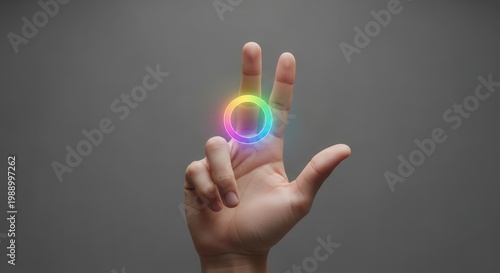 Human hand with two fingers featuring a vibrant, glowing rainbow digital ring interface element