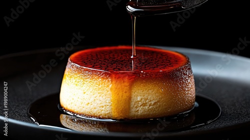 Rich caramel sauce drizzles onto a perfectly set custard dessert on a dark plate