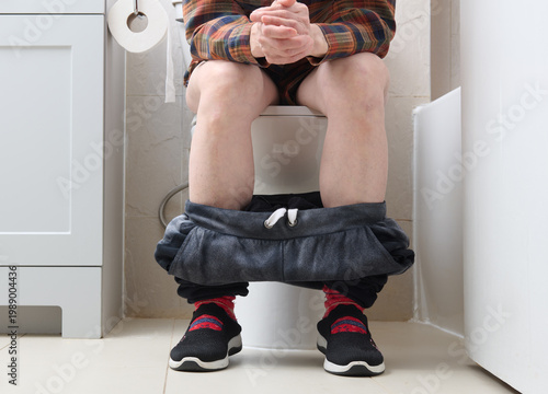 Woman Sitting Patiently on Toilet Lower Body