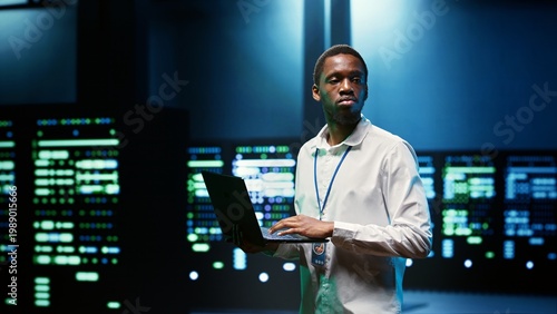 Φωτογραφία IT developer in server room using laptop to find network issues affecting superc