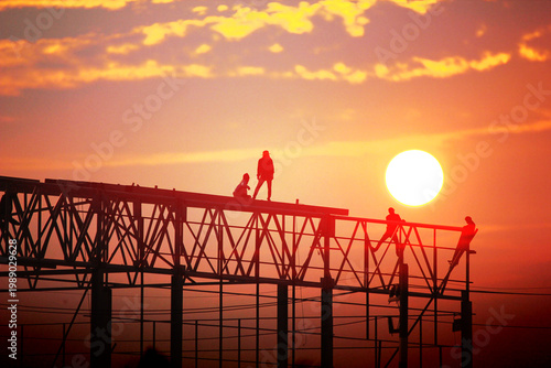 group of worker work late wilding steel structure in construction site on sun set abstract nature background